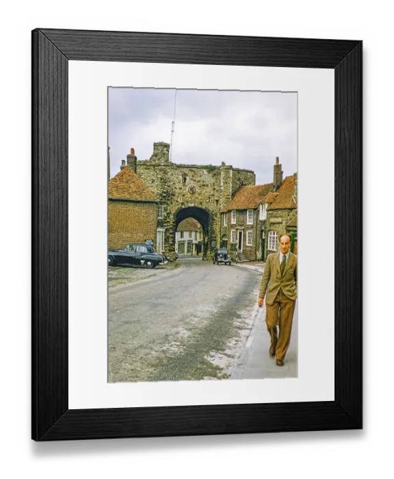 Framed Print : Man walking on the pavement with the Landgate gatehouse, Rye, East Sussex, England, UK 1956