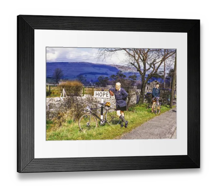Framed Print : Two male cyclists at the town sign of Hope, Peak District National Park, Derbyshire, England, UK 1956