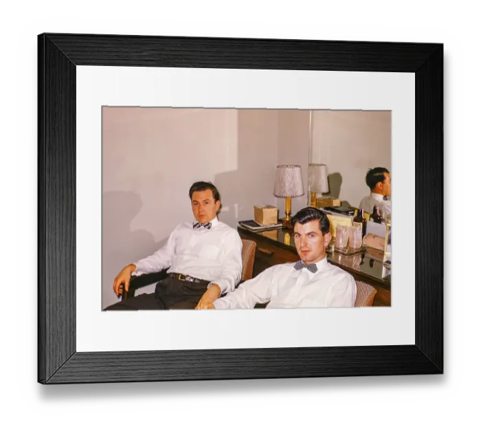 Framed Print : Two men in shirts and bow ties sitting in a hotel room with a mirror in the background, USA around 1953