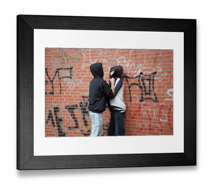 Framed Print : Teenager pushing a smaller boy violently against a wall, posed scene
