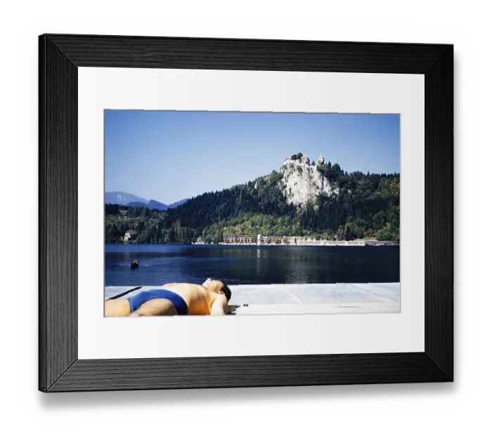 Framed Print : Man sunbathing by lakeside with view to castle, Bled, Slovenia, former Yugoslavia, Europe 1960, Europe