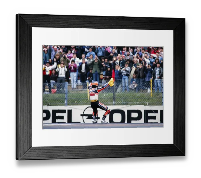Framed Print : The German Waldi Ralf Waldmann, Team Schuh, Zwafink, Honda, 125 cc, celebrates his first Grand Prix victory with the German flag in front of the fans at the Motorcycle World Championship at the Hockenheimring on 26 May 1991 in Germany Framed Print : The German Waldi Ralf Waldmann, Team Schuh, Zwafink, Honda, 125 cc, celebrates his first Grand Prix victory with the German flag in front of the fans at the Motorcycle World Championship at the Hockenheimring on 26 May 1991 in Germany