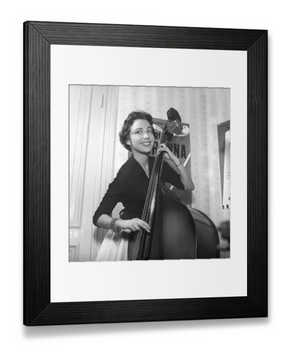 Framed Print : Girl in 1956. The photograph, taken in 1956, portrays a young woman with a bright smile as she plays a double bass