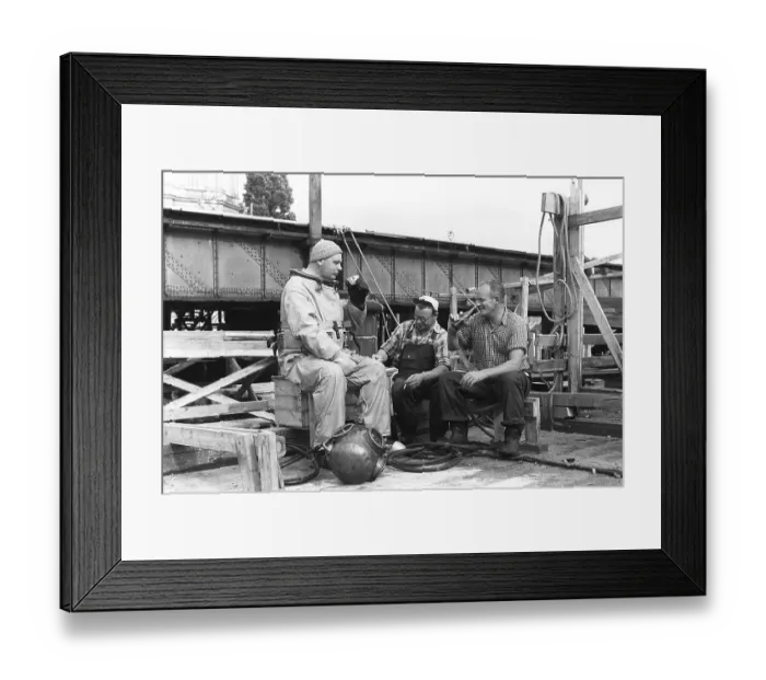 Framed Print : A diver in 1953, sitting in his diving suit and drinking coffee