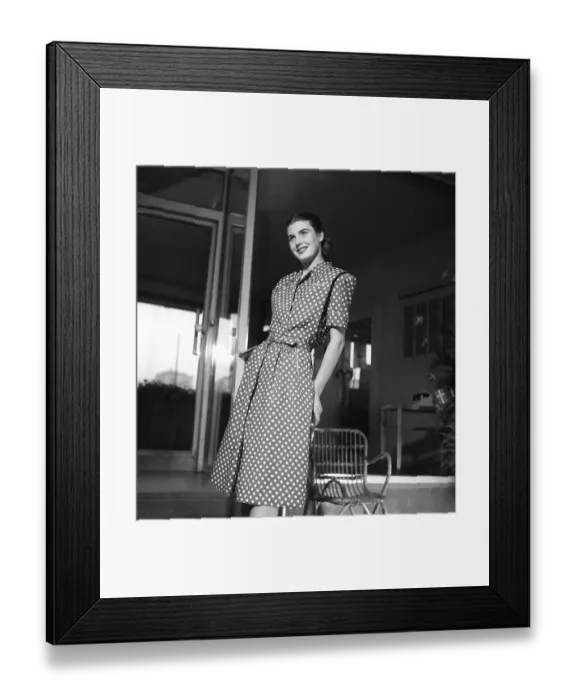 Framed Print : Fashion 1946, a young female model dressed in the fashion of the post war era. The dress with short sleeves reaching below the knees is in dark fabric with a pattern of white dots and has a waist band in the same fabric. Kristoffersson ref Y86-4