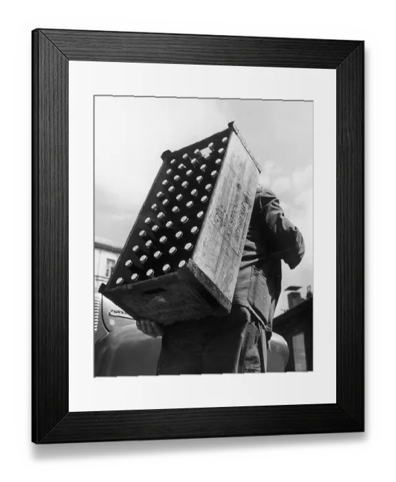 Framed Print : Beer in the 1930s. A man from the brewery AB Stockholms bryggerier carries a wooden crate with the brewery's symbol on the back. The crate holds fifty bottles of beer, which were delivered to shops and restaurants in Stockholm
