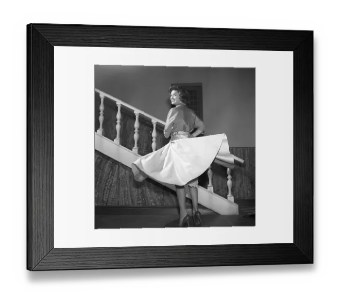 Framed Print : Girl in 1956. The photographer has captured the young woman in motion, her skirt lifting slightly as she moves, a joyful smile lighting up her face