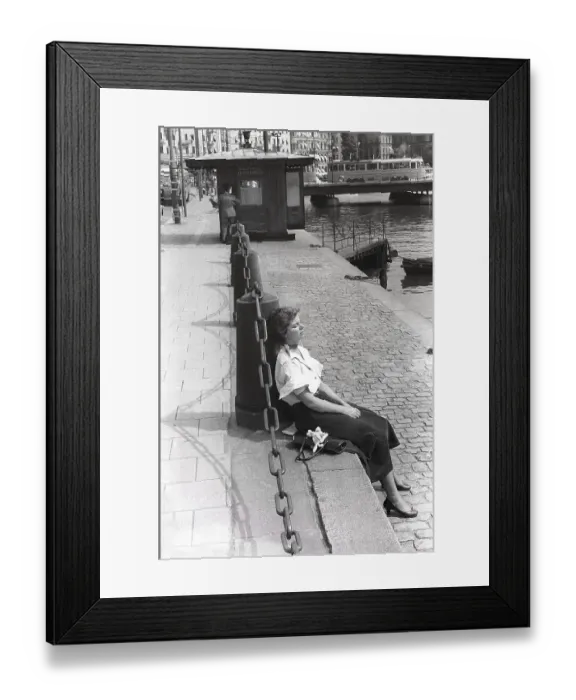 Framed Print : Young woman 1954. She is sitting in the sunshine with closed eyes enjoying the fine weather. She is wearing a white shirt and a skirt in Corduroy fabric