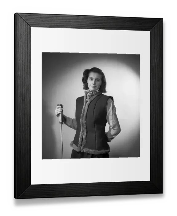 Framed Print : She is dressed in this year's fashion for outdoor and leisure use. A lined waistcoat with a long-sleeved knitted jumper underneath. She is holding a pair of ski poles to emphasise the outdoors Framed Print : She is dressed in this year's fashion for outdoor and leisure use. A lined waistcoat with a long-sleeved knitted jumper underneath. She is holding a pair of ski poles to emphasise the outdoors