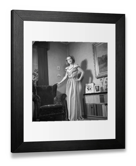 Framed Print : Fashion of 1946. A woman pictured wearing the typical fashion of the postwar era. She is wearing a long dress, the fabric of which is a pattern of narrow and wide fields of different colours