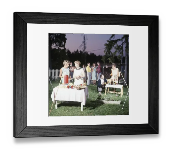 Framed Print : Garden party in the 1960s. A picture of a group of men and women at an outdoor party. Some are dancing to the music of an accordion. Food and drinks are on the tables and the people are nicely dressed for the evening. 1965. Roland Palm ref 02 / 32:6