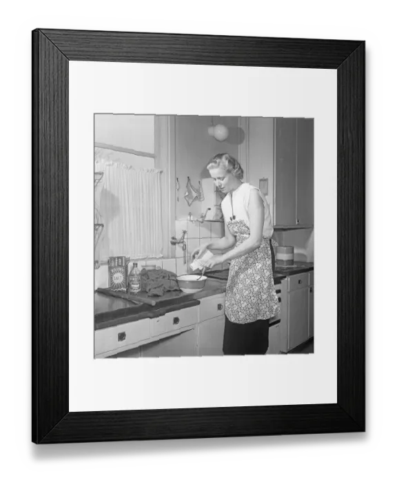 Framed Print : This is how it was done in the 1950s. A young woman stands at the kitchen sink and uses Bouvy salt with iodine to dye or wash her clothes. She rinses with clean water and looks pleased with the result. 1951. Kristoffersson ref BB68-8
