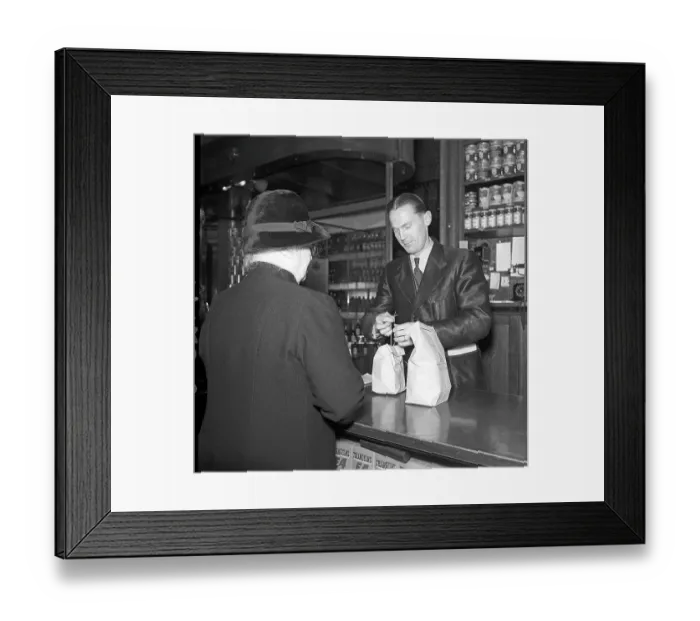 Framed Print : In the shop in 1942. A male assistant in Arvid Nordquist's delicatessen on Birgerjarlsgatan in Stockholm. The year is 1942 and World War II is raging in Europe. Despite the war, the company is able to offer groceries and delicacies