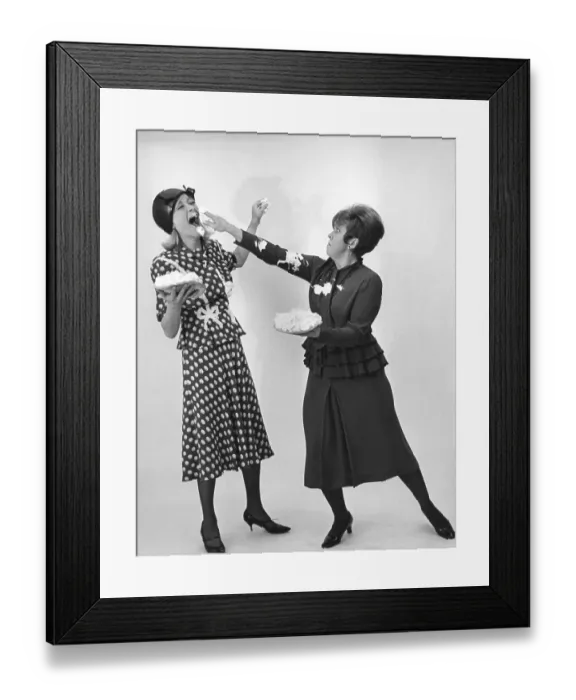 Framed Print : In the 1960s. A cake fight between two women. They have one cake with whipped cream each in their hands but have not yet landed the bullseye in each others face. They are actors Monica Zetterlund and Inga Gill. 1968 Framed Print : In the 1960s. A cake fight between two women. They have one cake with whipped cream each in their hands but have not yet landed the bullseye in each others face. They are actors Monica Zetterlund and Inga Gill. 1968
