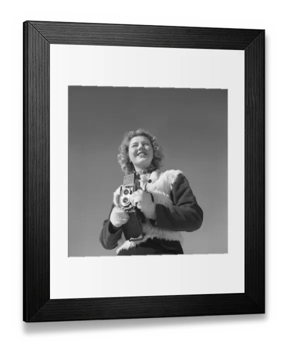 Framed Print : Winter in the 1940s. A young woman is photographing on a winter day