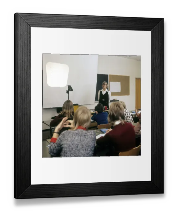 Framed Print : In the 1970s. A school class sits in the benches during a lesson with a female teacher