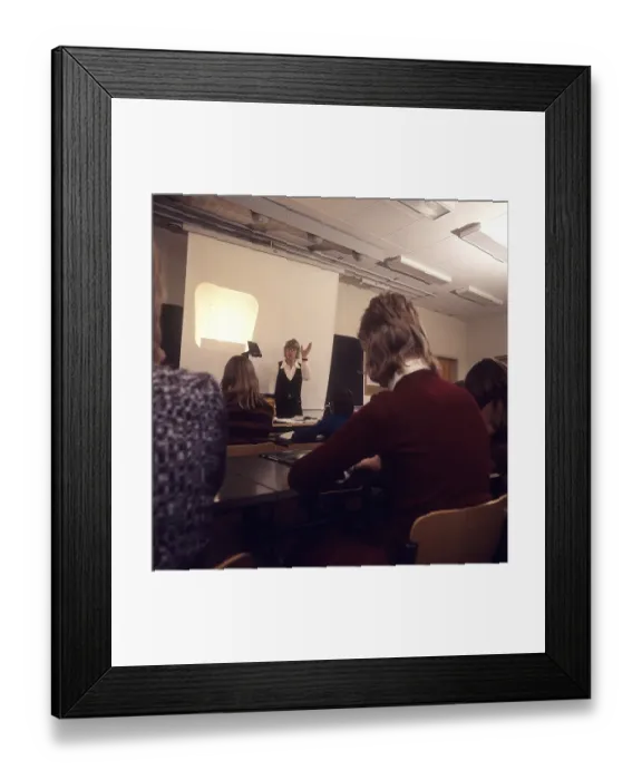 Framed Print : In the 1970s. A school class sits in the benches during a lesson with a female teacher Framed Print : In the 1970s. A school class sits in the benches during a lesson with a female teacher
