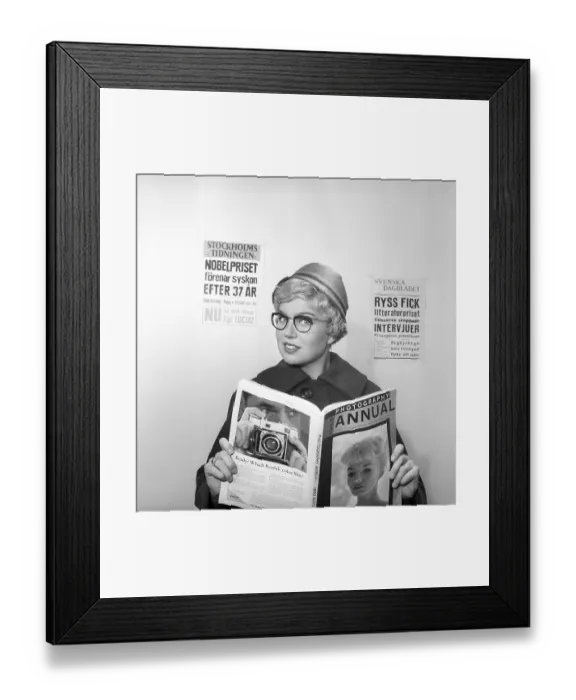 Framed Print : In the 1950s. A woman reads from the 1958 edition of Photography annual