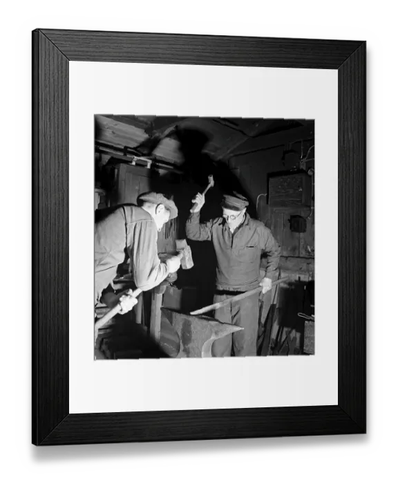 Framed Print : Craftsmen of the 1940s. Two blacksmiths in a forge, hammering a piece of metal against the anvil. Sweden 1947 Kristoffersson ref AB6-3