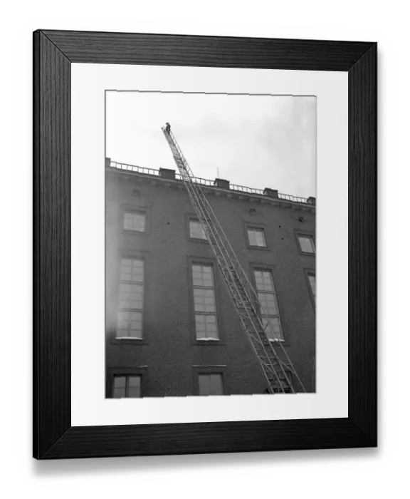Framed Print : Fire in the 1940s. Firefighter from Kungsholmen's fire station walks up the ladder that is set up against a house Framed Print : Fire in the 1940s. Firefighter from Kungsholmen's fire station walks up the ladder that is set up against a house
