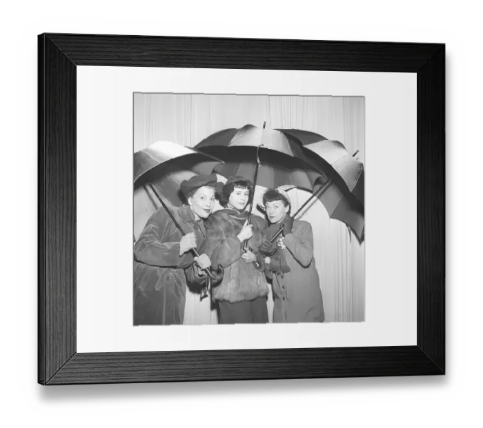 Framed Print : Three women under umbrellas in the 1950s