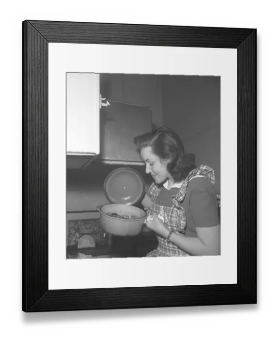 Framed Print : In the kitchen 1940s. Interior of a kitchen and a young woman lifting the lid of a saucepan steaming hot and looks happy with how it turned out. Sweden 1946 Kristoffersson ref CC122-1
