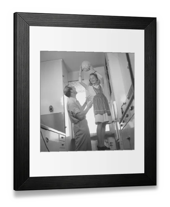 Framed Print : In the 1940s. A couple looking happy when playing around in the kitchen Framed Print : In the 1940s. A couple looking happy when playing around in the kitchen