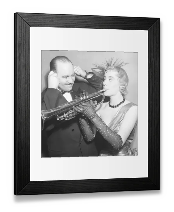 Framed Print : A young woman wearing an evening dress and arm-length gloves plays the trumpet Framed Print : A young woman wearing an evening dress and arm-length gloves plays the trumpet