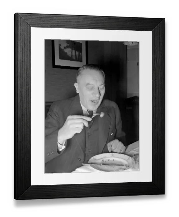 Framed Print : At christmas in the 1940s. A man is having christmas dinner and has a meatball on his fork ready to eat Framed Print : At christmas in the 1940s. A man is having christmas dinner and has a meatball on his fork ready to eat