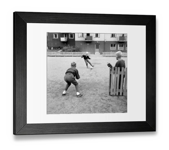 Framed Print : 1950s boys playing soccer. Children playing football on the open space in the living area Framed Print : 1950s boys playing soccer. Children playing football on the open space in the living area