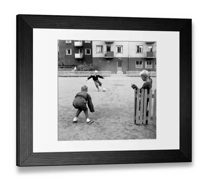 Framed Print : 1950s boys playing soccer. Children playing football on the open space in the living area