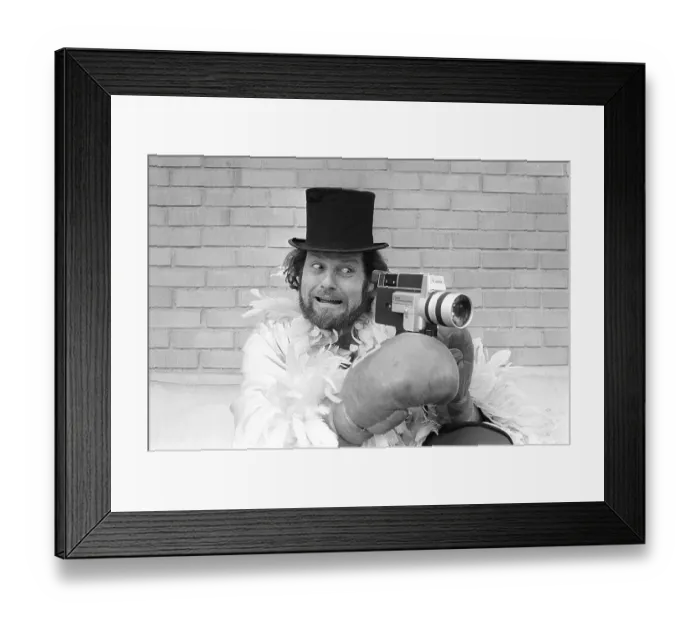 Framed Print : In the 1970s. A man is filming with a amateur film camera. The film was then developed and shown on a film projector on a fold up screen at home. Ricky Bruch (1946-2011) Swedish track and field athlete