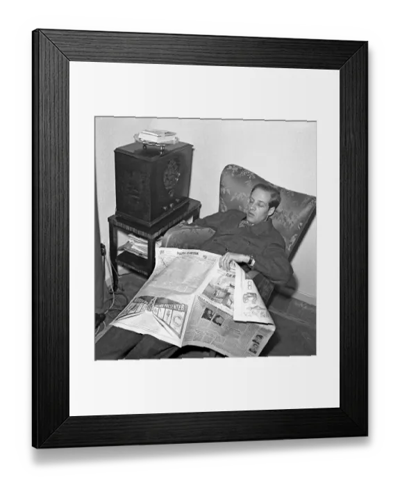 Framed Print : Radio listener in the 1940s. A man manages to fall asleep while reading the paper and listening to the radio. 1944. Kristoffersson ref L180-2