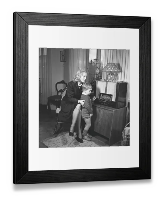 Framed Print : Radio in the 1940s. A mother and her son is listening to the radio
