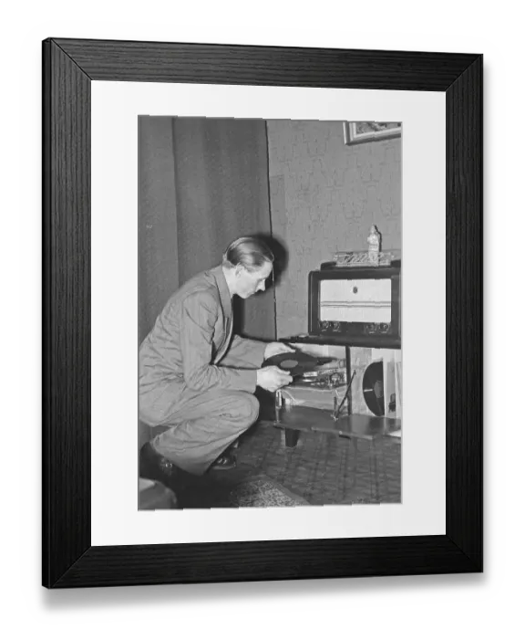 Framed Print : In the 1940s. World champion runner Gunder Haegg, 1918-2004, from Sweden pictured in his home while listening to music records on hthe gramophone. He also has a nice radio.1942
