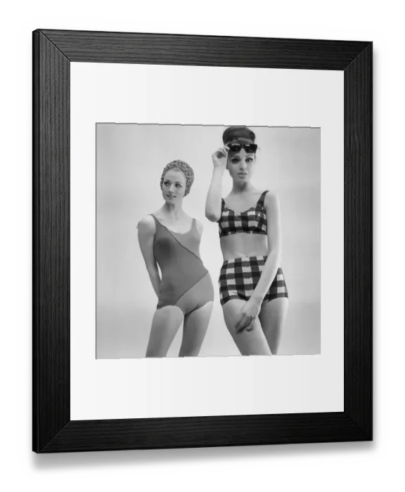 Framed Print : 1960s swimsuit fashion. Two models are wearing the swimsuit and bikini fashion of 1963