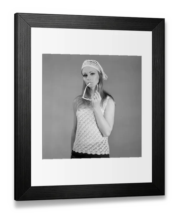 Framed Print : In the 1960s. A young woman in a photographers studio photographed wearing a knitted sleevless sweater