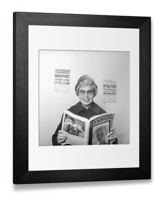 Framed Print : In the 1950s. A woman reads from the 1958 edition of Photography annual