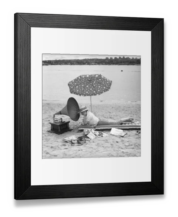 Framed Print : On the beach 1960. A young woman on a beach