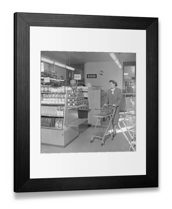 Framed Print : Shopping in the 1940s. A woman shops in a self service store