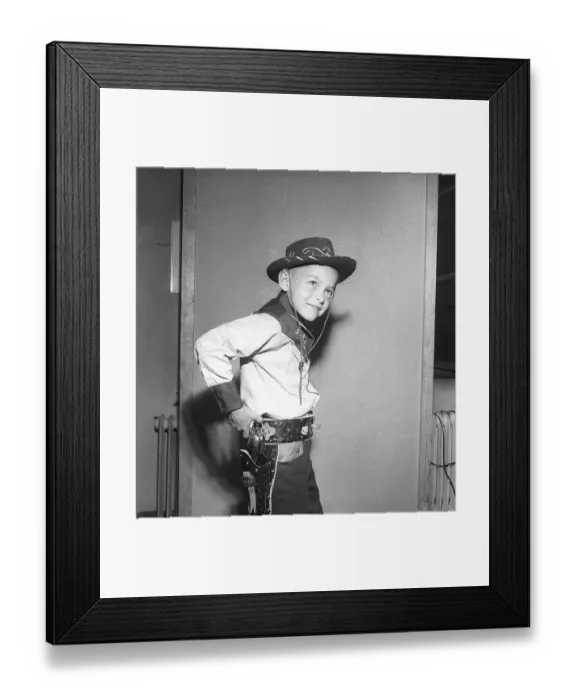 Framed Print : Boy in the 1950s. A boy is dressed in cowboy clothes