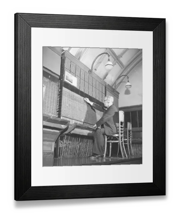 Framed Print : A telephone exchange. A man sits at a manual switchboard. All incoming and outgoing calls must be connected and he does this by connecting the cord and plug to the correct connection Framed Print : A telephone exchange. A man sits at a manual switchboard. All incoming and outgoing calls must be connected and he does this by connecting the cord and plug to the correct connection