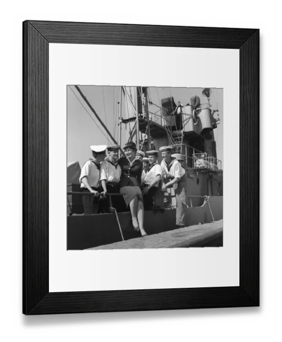 Framed Print : In the 1950s. A young woman in uniform at the dock surrounded by sailors from the crew of the ship Sturkoe, which belongs to the Swedish Navy. The picture was taken in Visby on the island of Gotland, Sweden in 1959. Kristoffersson ref CG40-5