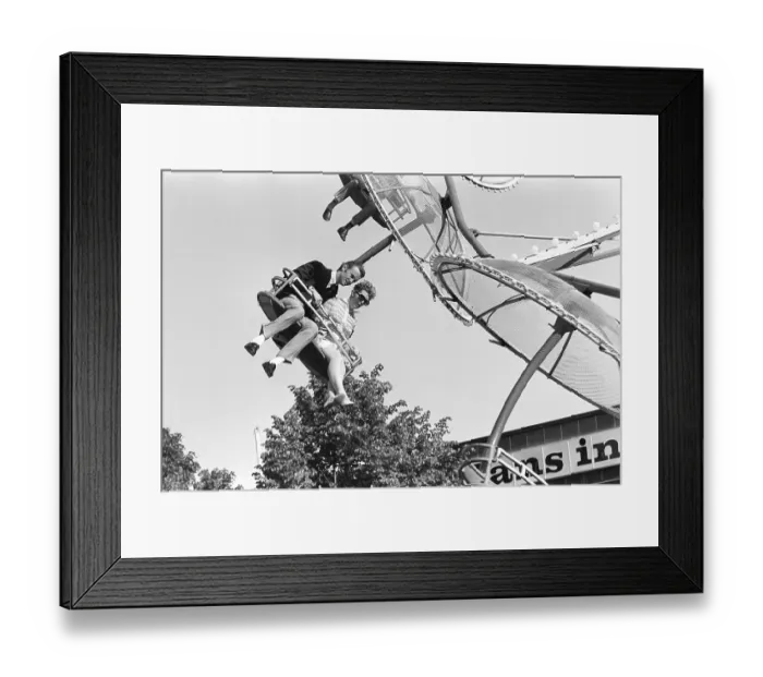 Framed Print : Amusement park in the 1960s. A couple is seen in one of the attractions that are offered on the grounds. They sit next to each other in a seat that moves round and round. Sweden 1968 Framed Print : Amusement park in the 1960s. A couple is seen in one of the attractions that are offered on the grounds. They sit next to each other in a seat that moves round and round. Sweden 1968