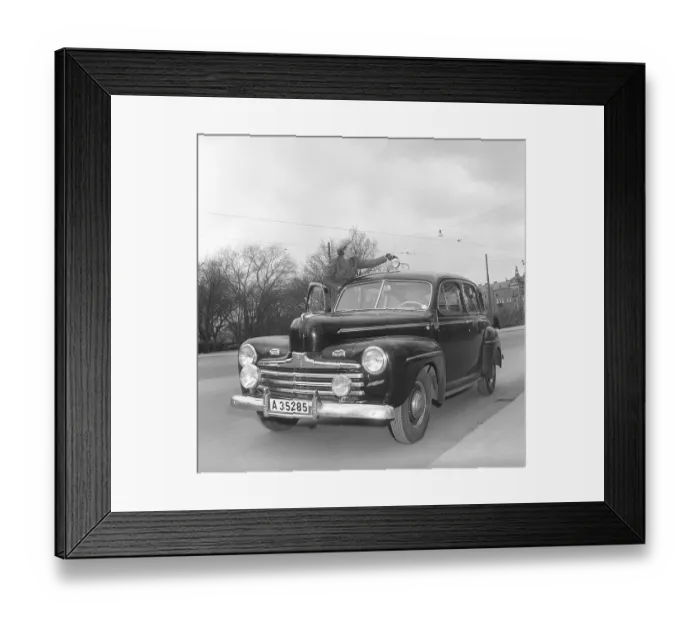 Framed Print : In the 1940s. A young woman by her passenger car of the American car brand Ford. She is dressed in a two-piece suit, skirt and short jacket in herringbone wool fabric Framed Print : In the 1940s. A young woman by her passenger car of the American car brand Ford. She is dressed in a two-piece suit, skirt and short jacket in herringbone wool fabric