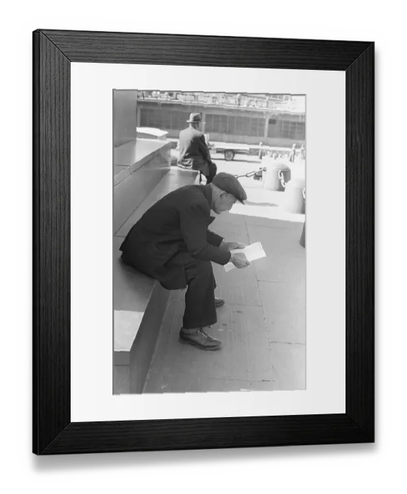 Framed Print : In the 1950s. An elderly man sittting on the steps reading the list of starting horses at the upcoming horseraces Framed Print : In the 1950s. An elderly man sittting on the steps reading the list of starting horses at the upcoming horseraces