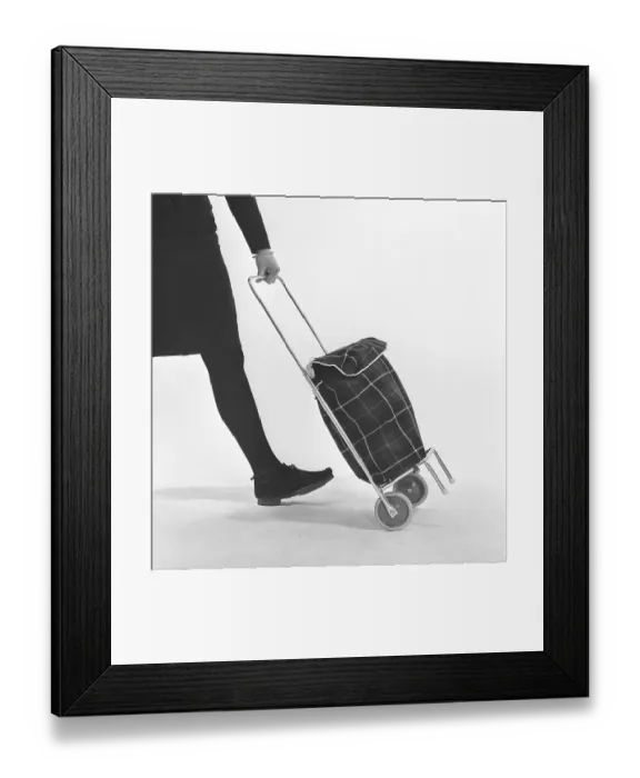 Framed Print : Shopping in the 1960s. A young lady uses her shopping cart for transporting her groceries Framed Print : Shopping in the 1960s. A young lady uses her shopping cart for transporting her groceries