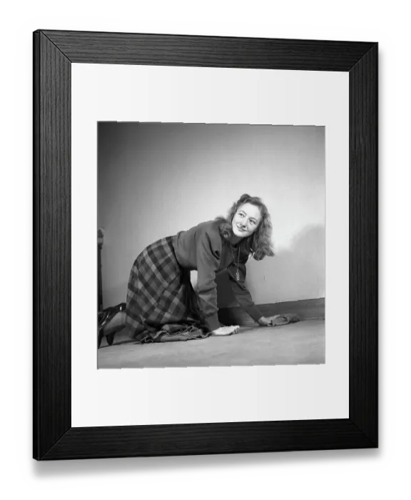 Framed Print : Woman in the past. A woman is kneeling on the floor and wiping and cleans the carpet with a cloth