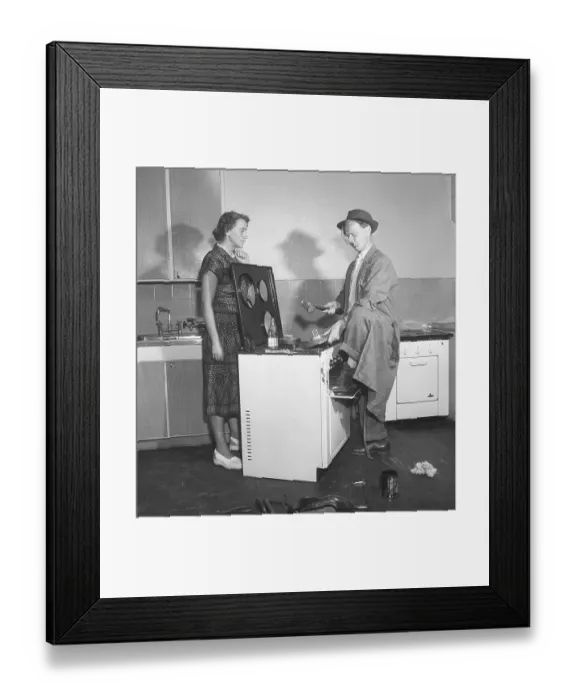 Framed Print : In the 1950s. A man at an electric cooker from swedish manufacturer Husqvarna, doing some work on the stove looking very non-professional.A woman is standing on the side looking at him in a skeptical manor. Sweden 1950. Kristoffersson ref AZ69-12