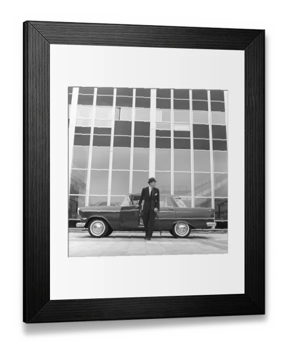 Framed Print : In the 1960s. A man is seen standing at his car